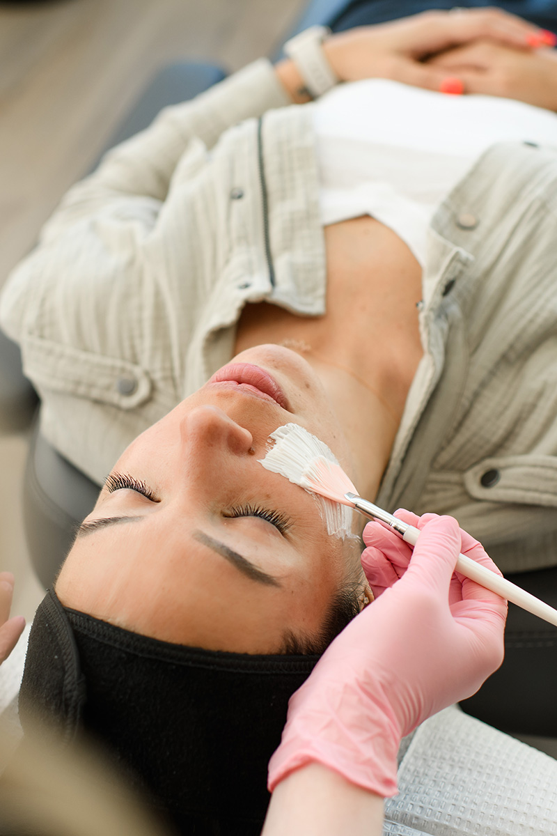 an Evolve Aesthetics & Wellness aesthetician applying a facial cream to a client