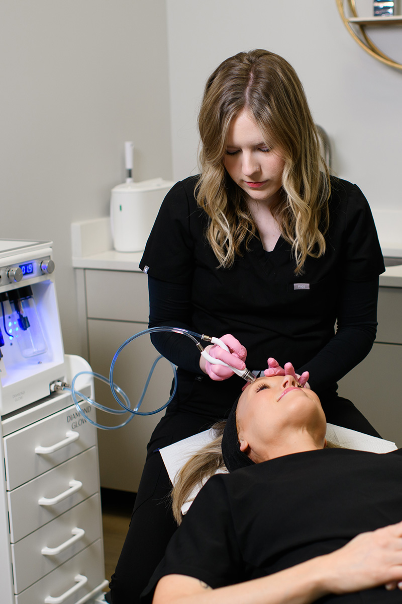 an Evolve Aesthetics & Wellness aesthetician performing a Diamond Glow treatment