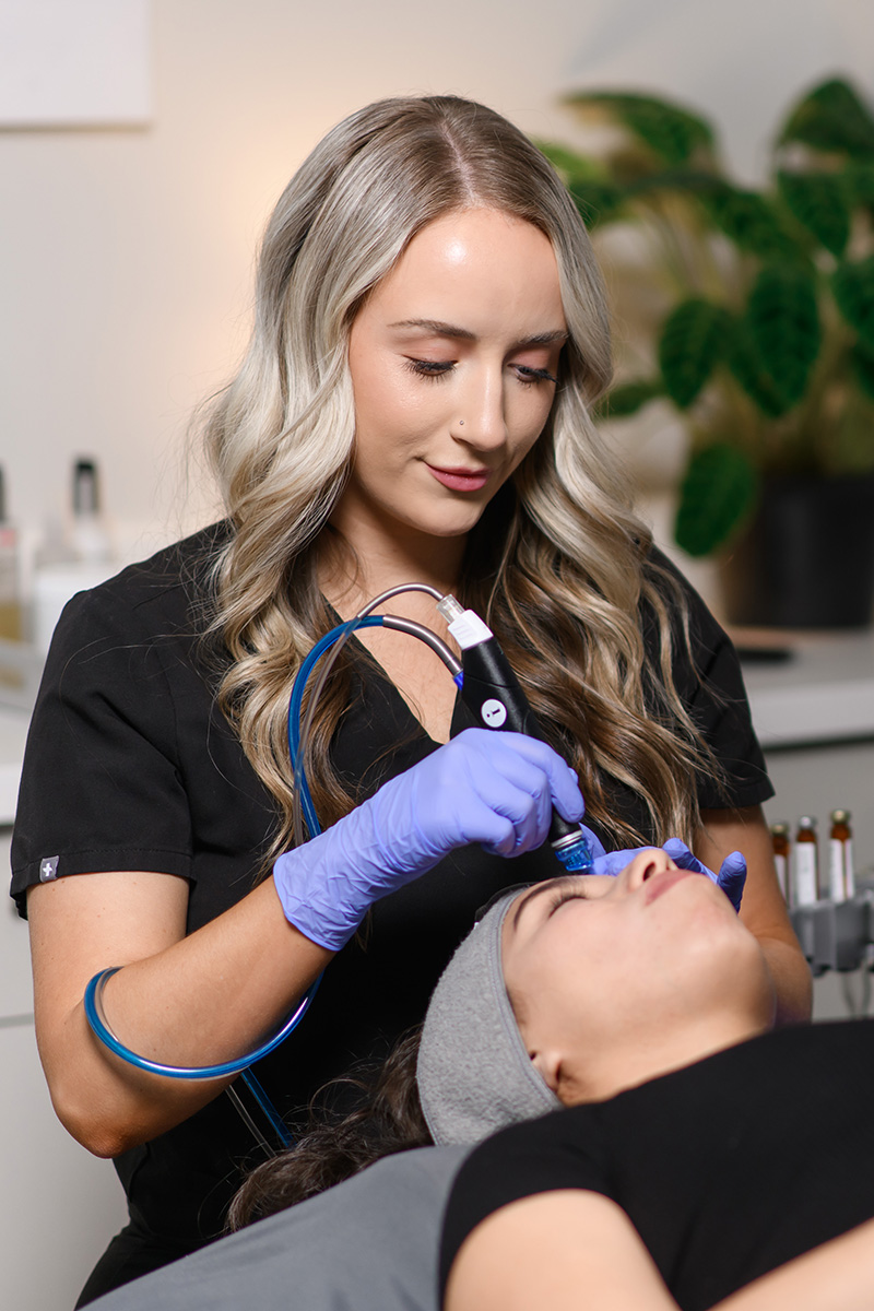 an Evolve Aesthetics & Wellness aesthetician performing a Hydrafacial for a client