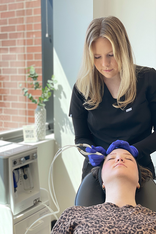 an Evolve Aesthetics & Wellness aesthetician performing a Diamond Glow treatment