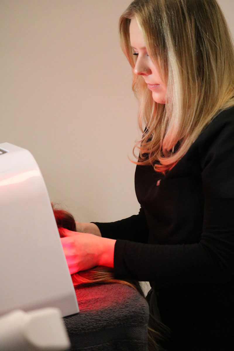 an Evolve Aesthetics & Wellness aesthetician performing LED light therapy on a client