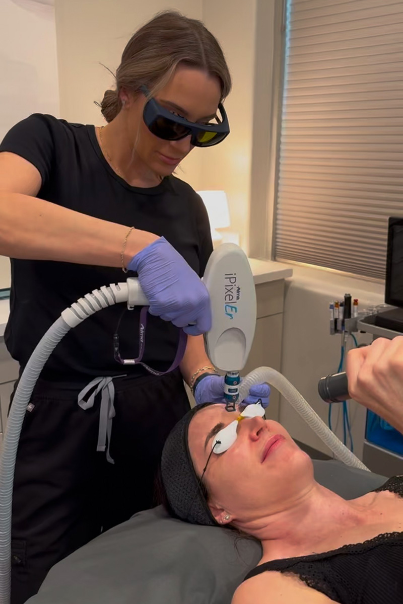 an Evolve Aesthetics & Wellness aesthetician performing a Pixel laser treatment on a patient